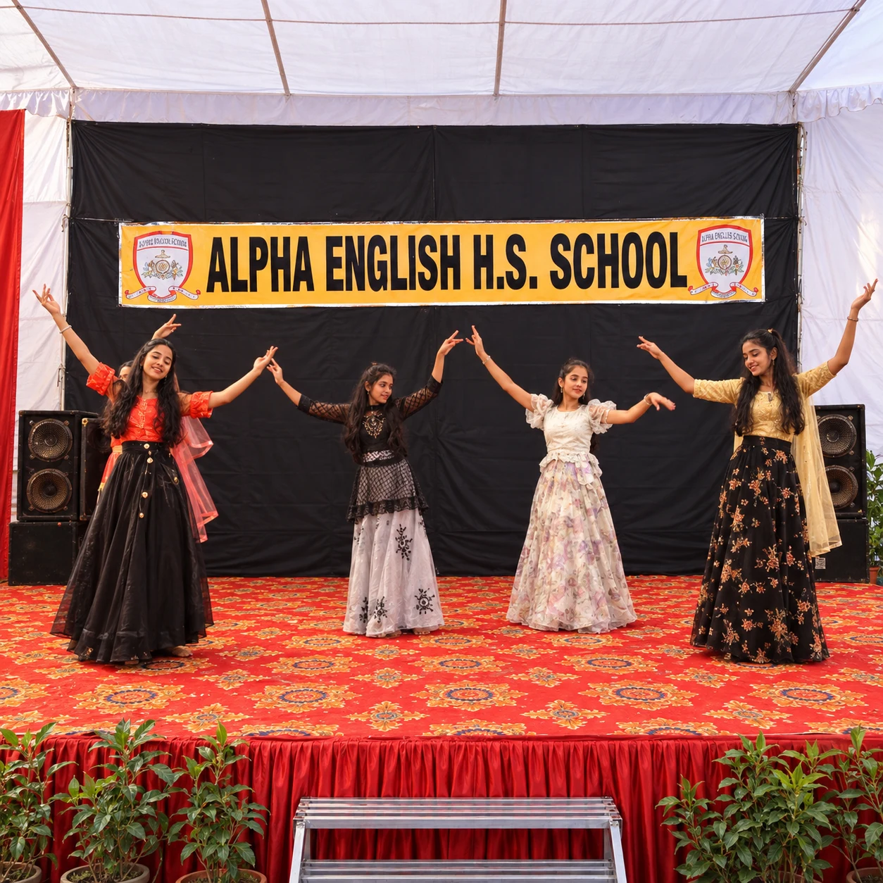 Students performing traditional cultural dance on stage in front of Alpha English H.S. School banner